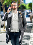 stylish businessman using smartphone having phone call walking in city street