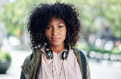 portrait african american woman in city street wearing headphones