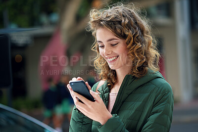 Buy stock photo Happy woman, smile and typing on phone during travel in city using social media, internet and 5g network connection outside. Young female flirting on a mobile app for communication on urban street