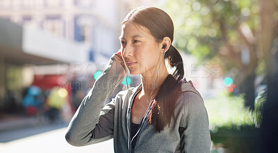 Buy stock photo Asian woman, earphones and music streaming while in the city for travel, exercise or run on a sunny day. Calm female listening to podcast, radio or audio on an urban street or sidewalk in summer