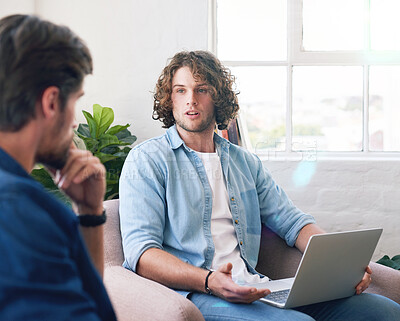 Buy stock photo young man uisng laptop chatting to friend brainstorming ideas for project sitting on couch at home