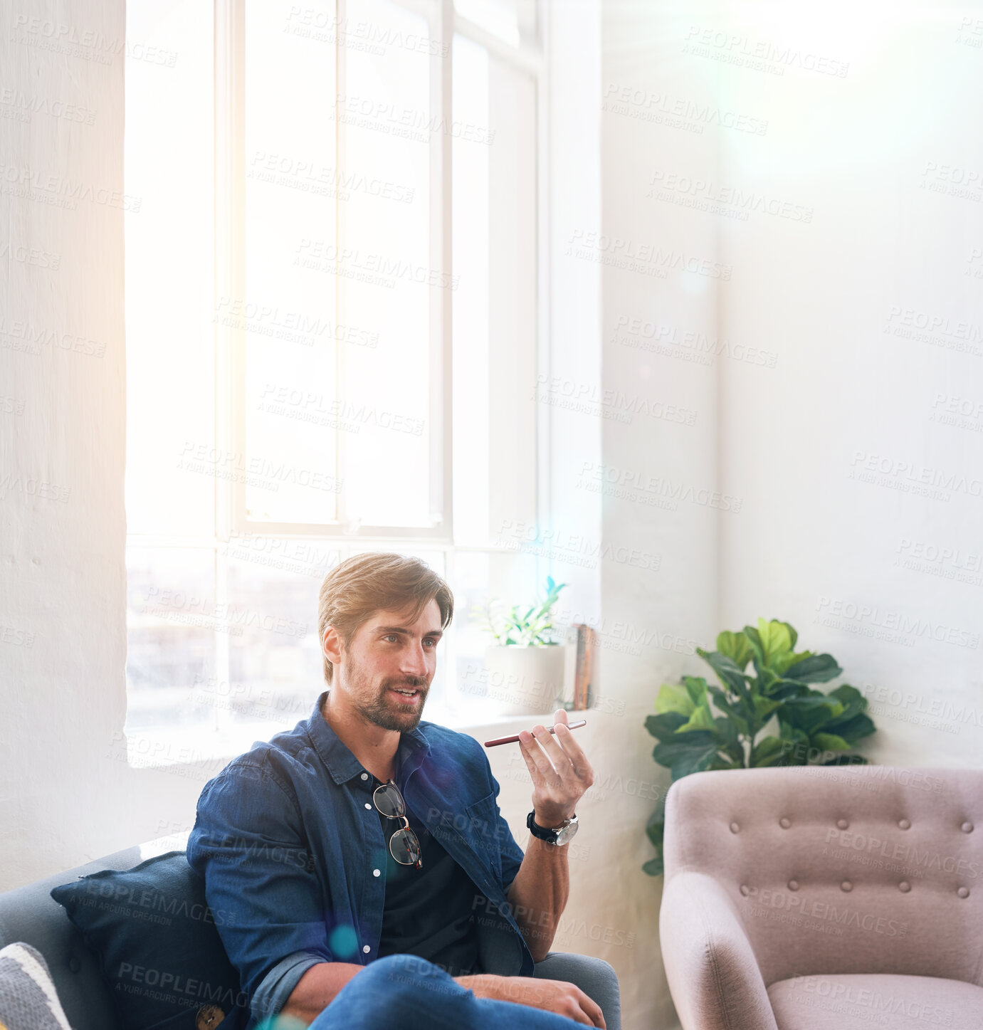 Buy stock photo Attractive man using smartphone having phone call sitting on sofa at home