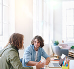 College students working together two young men brainstorming ideas for project sitting at desk using laptop computer in class