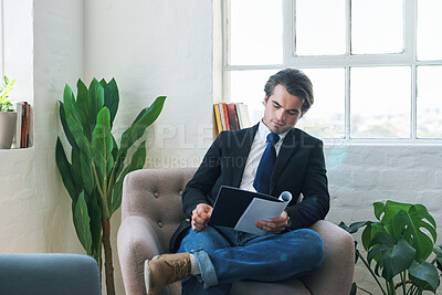 Buy stock photo Young businessman reading paperwork, on couch at home and looking at financial analysis document for career development. Business finance report, changes in economy and success with accounting audit 