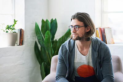 Buy stock photo Young man looking out window thinking sitting on sofa at home