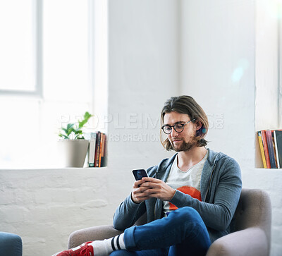 Buy stock photo Young man using smartphone at home texting  reading social media messages browsing online