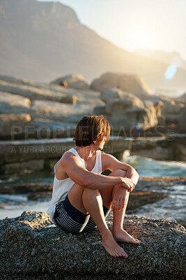 Buy stock photo young man sitting on beach looking at sunset watching ocean contemplating journey