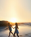 woman friends running on beach at sunset holding hands having fun summer vacation enjoying freedom