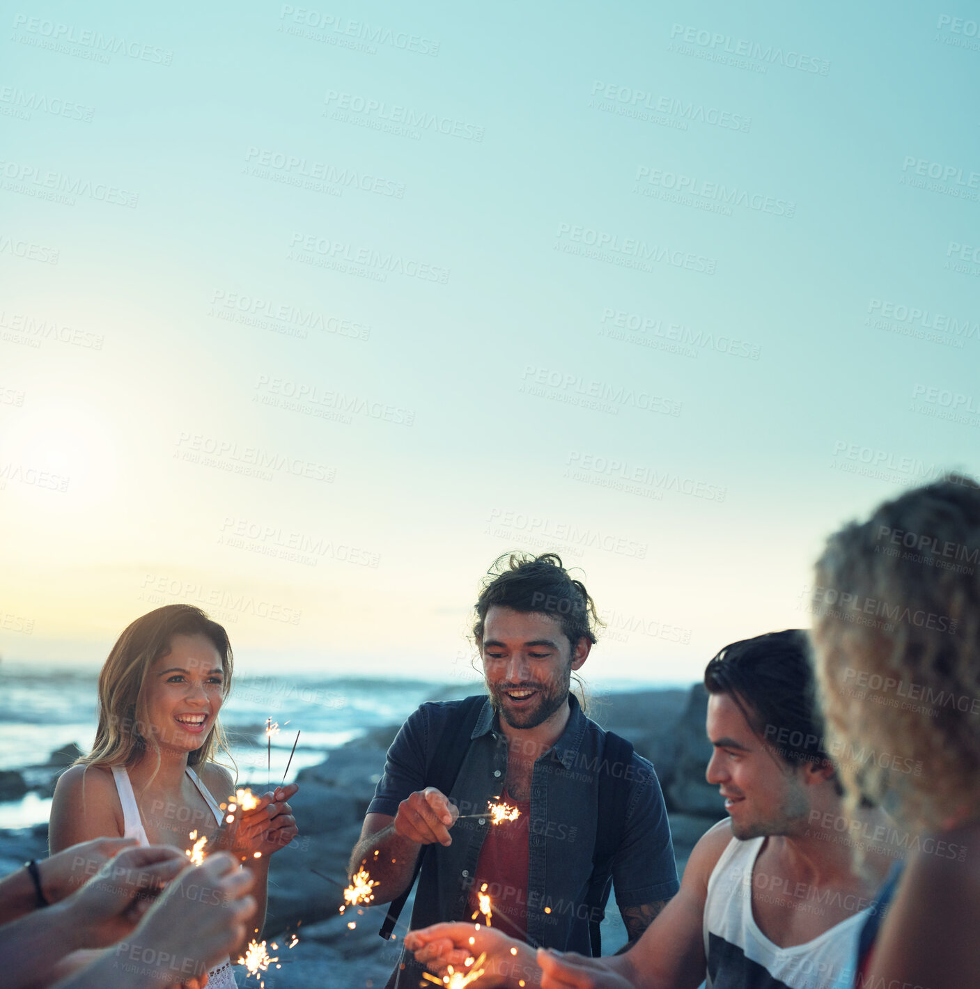 Buy stock photo friends with sparklers celebrating new years eve on beach at sunset