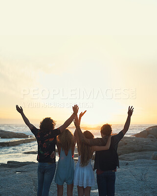 Buy stock photo group of friends celebrating arms raised on beach looking at beautiful sunset enjoying summer vacation lifestyle