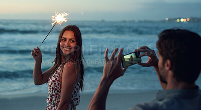 Buy stock photo Beautiful woman holding sparkler posing for photo on romantic beach celebrating new years eve at sunset