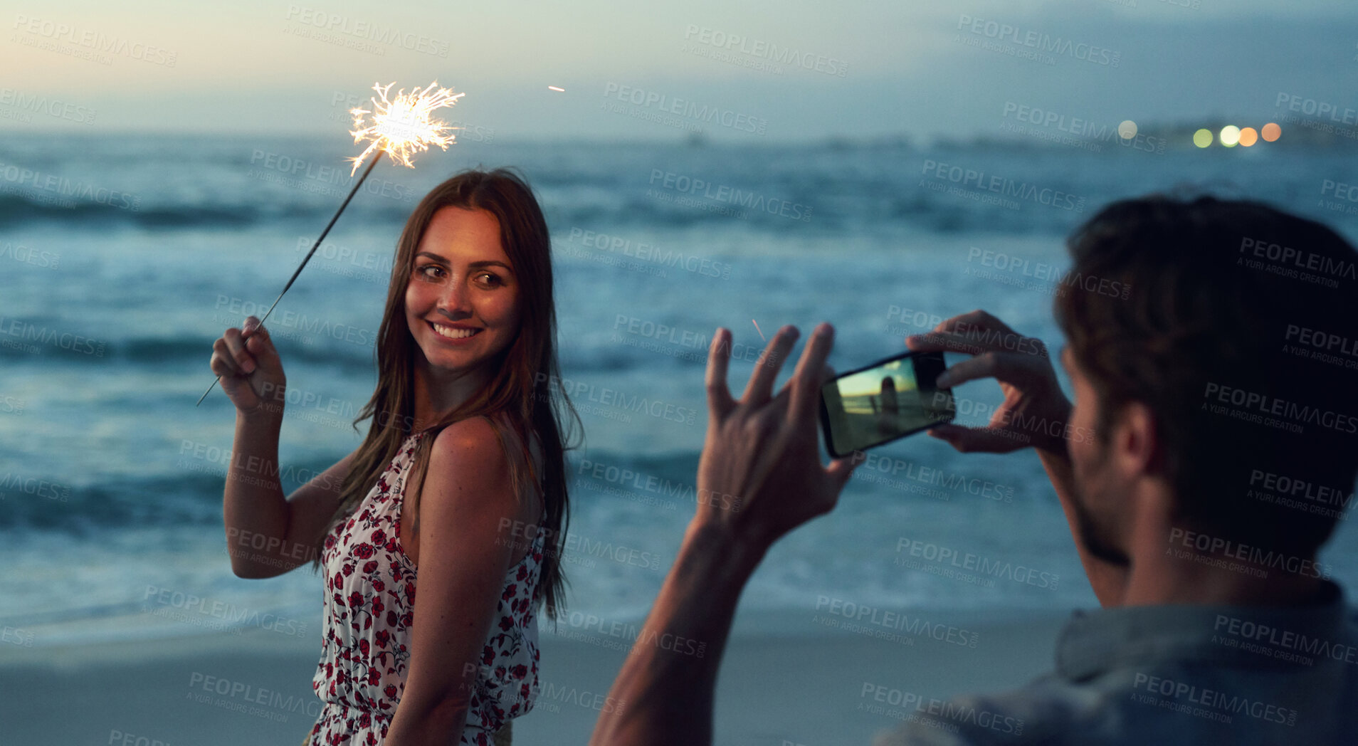 Buy stock photo Beautiful woman holding sparkler posing for photo on romantic beach celebrating new years eve at sunset