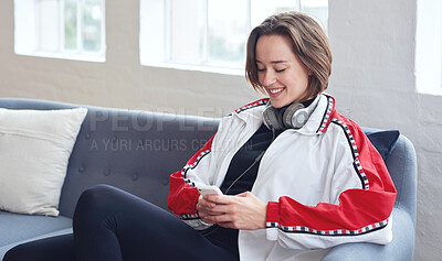 Buy stock photo Beautiful woman using smartphone browsing messages on social media texting on mobile phone sitting on sofa at home