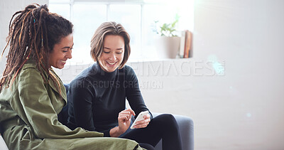Buy stock photo Two women friends using smartphone sitting on sofa at home browsing internet watching online entertainment on mobile phone