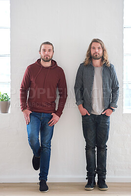Buy stock photo Portrait of twin brothers standing by a wall together in studio. Young twins, siblings and family of young men side by side. Relationship with brother, brotherhood and two guys who look identical