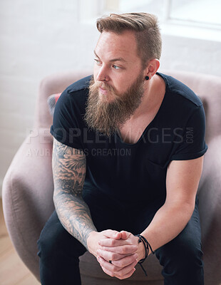 Buy stock photo Young hipster man with beard sitting looking out window contemplating