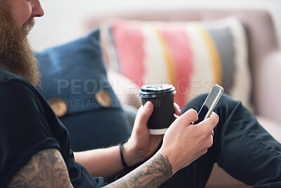 Buy stock photo hipster man using smartphone browsing messages on social media texting on mobile phone holding coffee