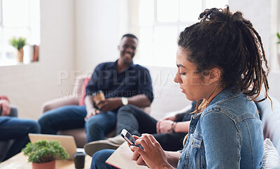 Buy stock photo Young woman using smartphone browsing messages on social media texting on mobile phone sitting on sofa hanging out with friends