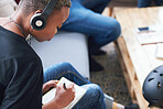 African american woman writing notes female student brainstorming listening to music wearing headphones