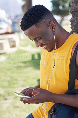 Buy stock photo African american man using smartphone listening to music relaxing outdoors in park enjoying summer