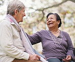 Elderly women sitting on bench in park smiling happy life long friends enjoying retirement