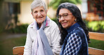 Two old women sitting on bench in park smiling happy life long friends enjoying retirement together