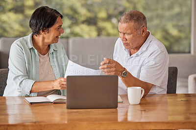 Buy stock photo Elderly couple paying bills online on a laptop, sitting by a table at home getting angry, planning retirement. Senior hispanic man and woman having a dispute over finance and debt