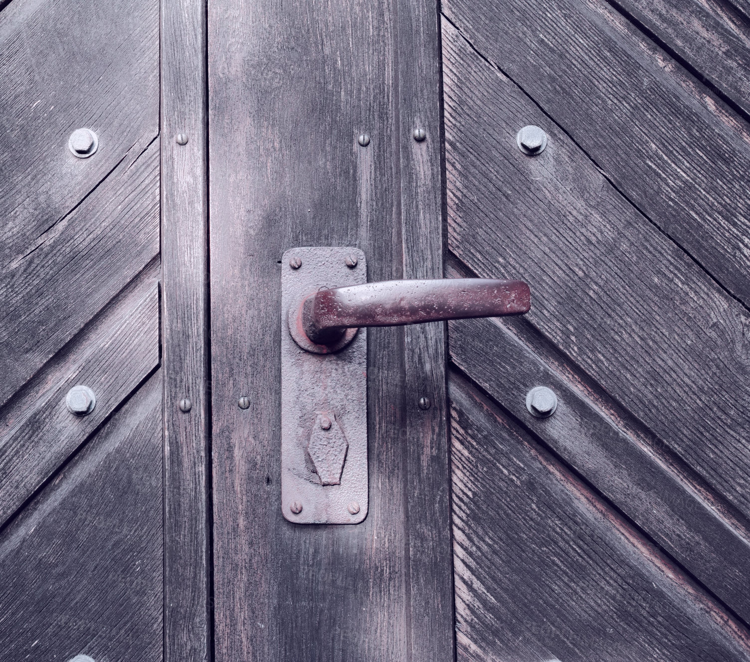 Buy stock photo A strange old wooden entrance door with a rusted door handle. A vintage door knob. Closeup of a traditional door with a handle and a lock. A copy space background. The gate knob is made of metal. 