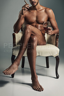 Buy stock photo Studio shot of a handsome young man having a drink and cigar in the nude against a grey background