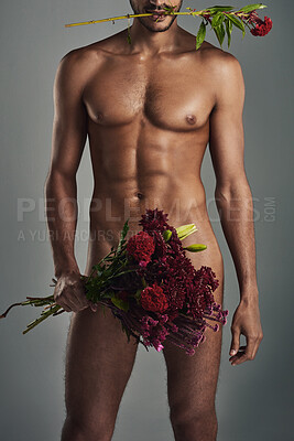 Buy stock photo Studio shot of a handsome young man holding a bunch of roses in the nude against a grey background