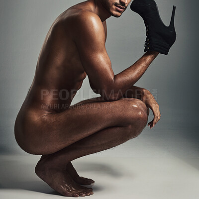Buy stock photo Studio shot of a handsome and muscular young man holding stilettos in the nude against a grey background