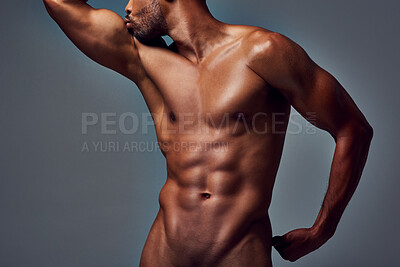 Buy stock photo Studio shot of a muscular young man kissing his bicep while posing nude against a grey background