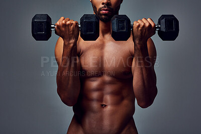 Buy stock photo Studio portrait of a muscular young man working out with dumbbells naked against a grey background