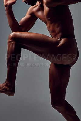 Buy stock photo Studio shot of a muscular young man running nude against a grey background