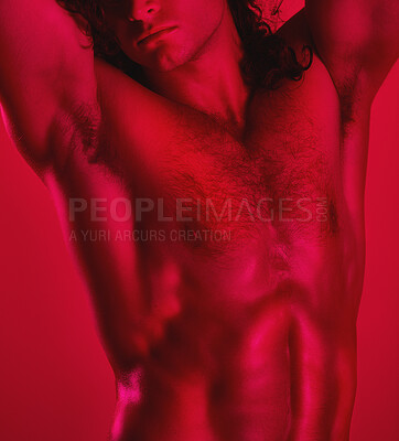 Buy stock photo Studio portrait of a muscular young man posing shirtless against a red background