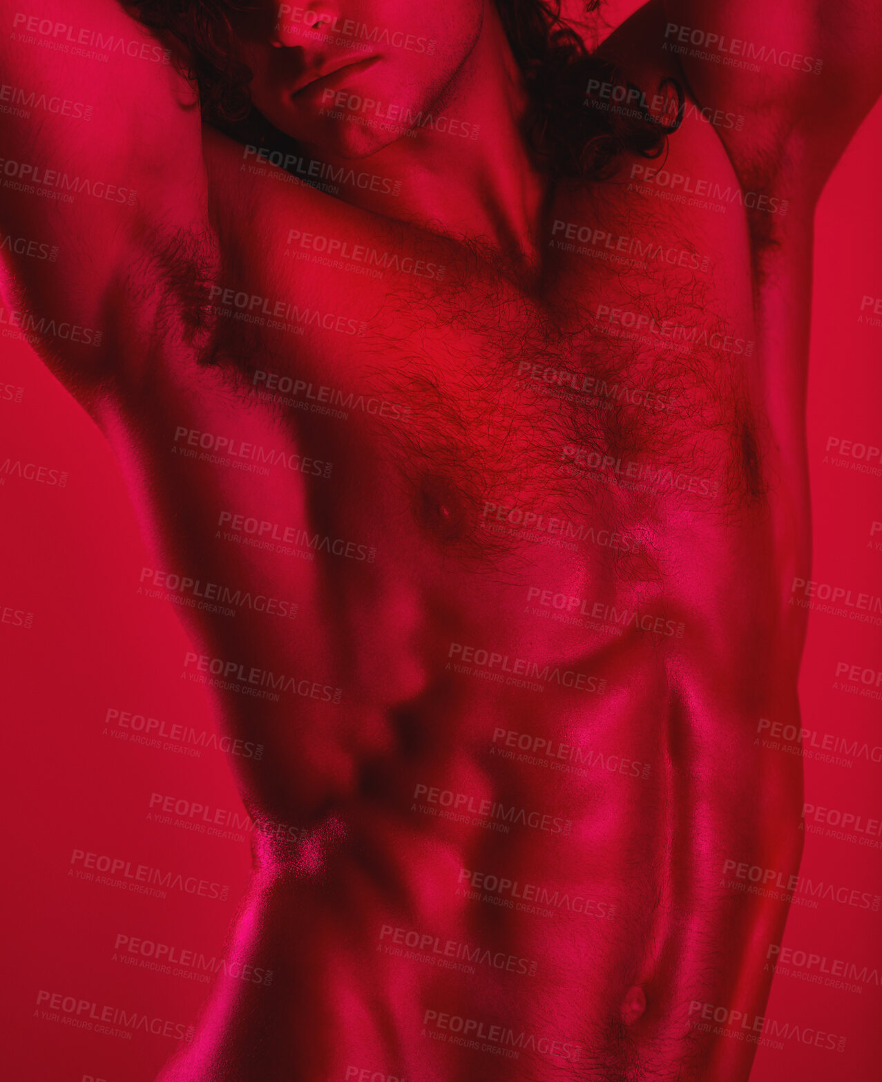 Buy stock photo Studio shot of a muscular young man posing shirtless against a red background