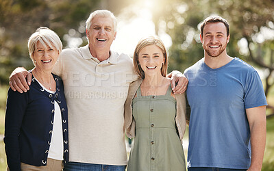 Buy stock photo Portrait of a loving caucasian family with adult children standing together in nature on a sunny day.  Happy senior couple posing outdoors with their daughter and son in law