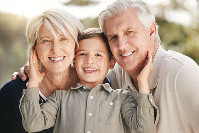 Buy stock photo Portrait of loving caucasian grandparents enjoying time with grandson in nature. Smiling little boy bonding with grandmother and grandfather touching their faces while they pose together