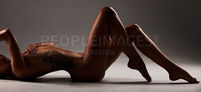 Buy stock photo Studio shot of a beautiful woman posing nude against a black background