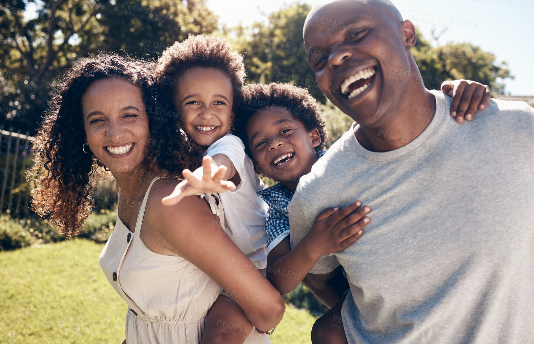 Buy stock photo Cheerful young african american parents playing with their little sons in the garden. Excited mother and father carrying their sons on piggyback rides. Smiling couple enjoying a day in the park 