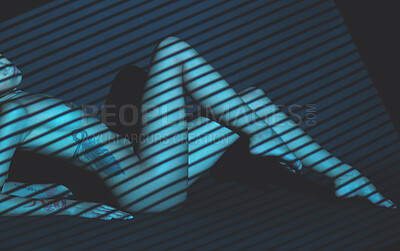 Nude mixed race woman posing while lying on the ground in a dark studio. Sexy hot naked hispanic model showing her body in creative and artistic light. Nudist feeling sensual, seductive and free