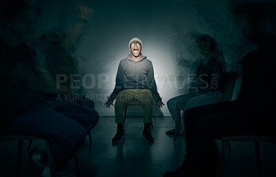 Buy stock photo One African American male suffering mental illness in asylum. Black schizophrenic man experiencing a breakdown while being surrounded by people on a stage theatre performance