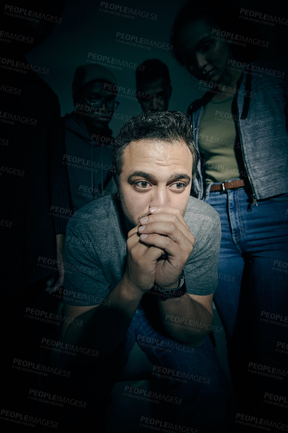 Buy stock photo One mixed race male suffering mental illness in asylum. Caucasian schizophrenic man experiencing a depression while being surrounded by people on a stage theatre performance
