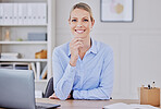 Portrait of one beautiful young caucasian businesswoman working on her laptop in the office at work. Confident and successful female entrepreneur sitting at her desk in her corporate workplace looking motivated and happy