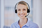 Smiling young caucasian female call centre agent talking on headset while working in an office. Confident and happy businesswoman consulting and operating a helpdesk for customer sales and service support