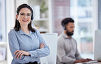 Portrait of one confident young caucasian woman standing with arms crossed while working in a call centre with her colleague in the background. Happy manager and ambitious supervisor determined to provide the best customer service and sales support