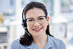Portrait of one happy young caucasian call centre telemarketing agent wearing glasses and talking on headset while working in office. Face of confident friendly female consultant operating helpdesk for customer service and sales support