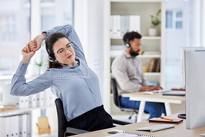 Young caucasian call centre telemarketing agent stretching her arms while working in an office. Female consultant taking a break after tiring workday of operating helpdesk for customer service and sales support