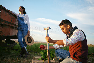 Buy stock photo Two farmers working on a field. Young mixed race man and brunette woman working together on their agricultural land. Harvest season always provides the best organic produce