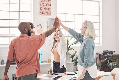 Group of diverse businesspeople giving each other a high five in an office at work. Business professionals having fun joining their hands for support and motivation during a meeting